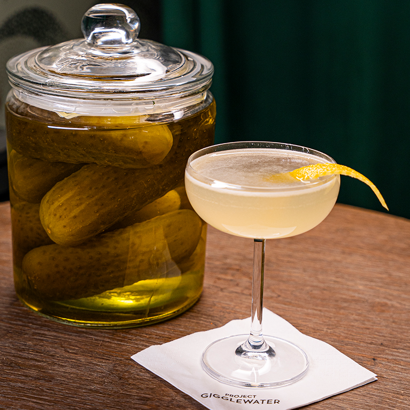 A cornichon 75 cocktail made with Prince Igor Extreme Pickle Flavoured Vodka and a jar of pickles
